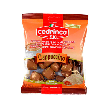 A bag of Cedrinca 1910 Cappuccino flavored filled candies, shown against a plain white background. The packaging is predominantly orange and red with a clear window displaying the brown candy pieces inside.