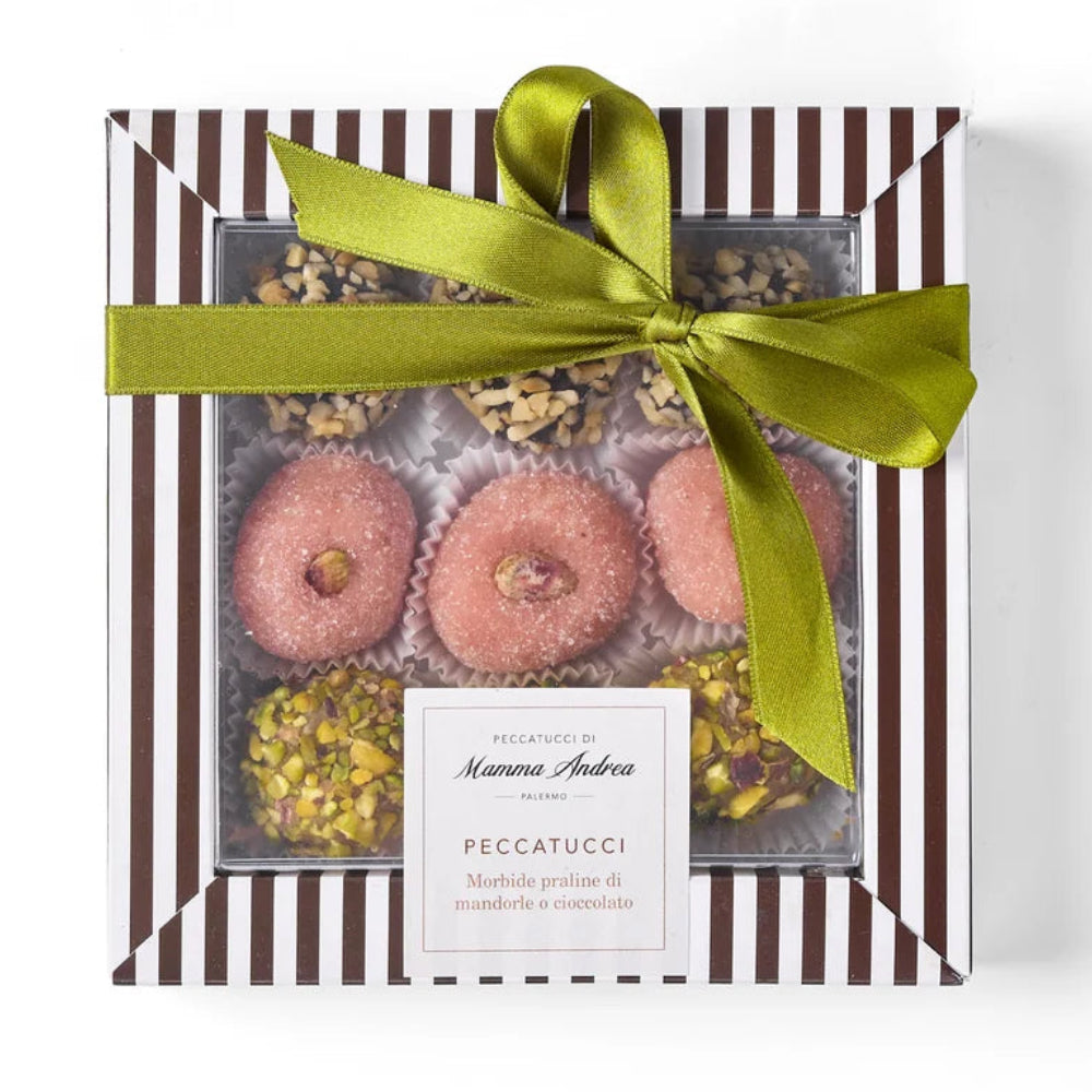 Gift box with a green ribbon containing pastries and pistachios, branded 'Peccatucci'.
