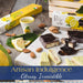 Artisan lemon chocolate bars and boxes of Perle sole on a rustic wooden table, styled with lemon slices, almonds, cookies, and a marble serving board.
