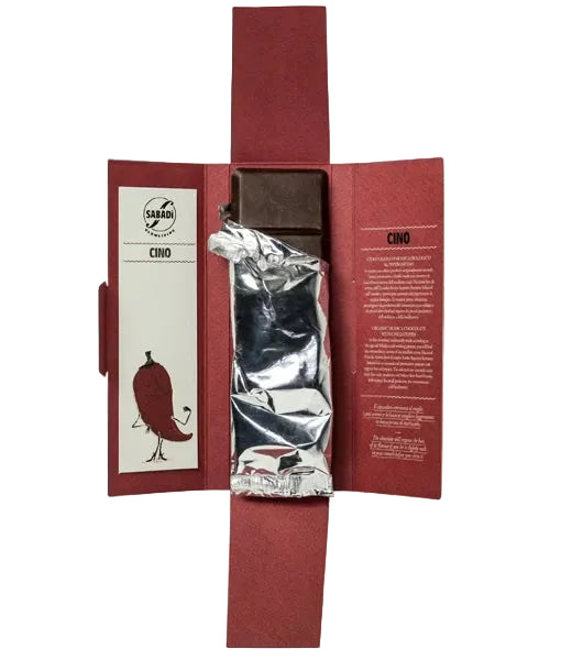 A Sabadi Modica chili pepper chocolate bar in its signature deep red paper packaging, shown open to reveal the silver foil-wrapped chocolate bar in the center.